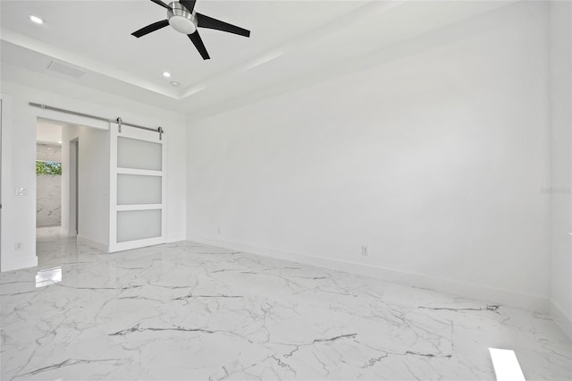 16506 Cape Horn Blvd, Punta Gorda, FL 33955 - empty room with a barn door, ceiling fan, marble finish flooring, recessed lighting, and a raised ceiling