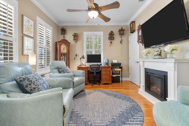 233 Durrance St, Punta Gorda, FL 33950 - home office with light wood-style flooring, ceiling fan, a glass covered fireplace, and ornamental molding
