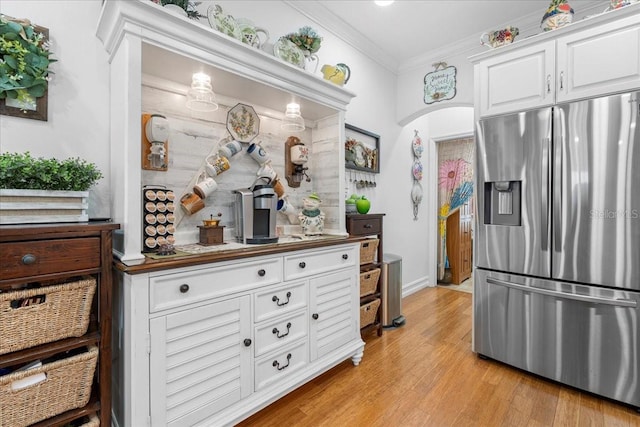 233 Durrance St, Punta Gorda, FL 33950 - kitchen featuring stainless steel fridge, crown molding, white cabinetry, and light wood-type flooring