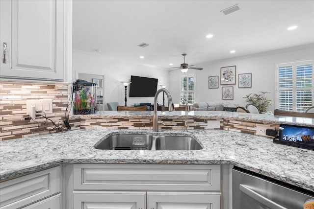 233 Durrance St, Punta Gorda, FL 33950 - kitchen featuring stainless steel dishwasher, ceiling fan, decorative backsplash, open floor plan, and white cabinets