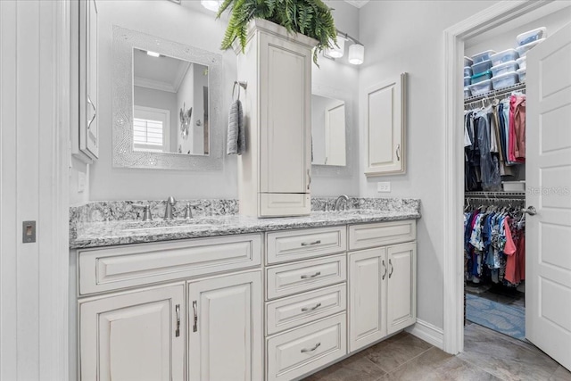 233 Durrance St, Punta Gorda, FL 33950 - bathroom featuring crown molding, double vanity, a spacious closet, and marble look tile flooring