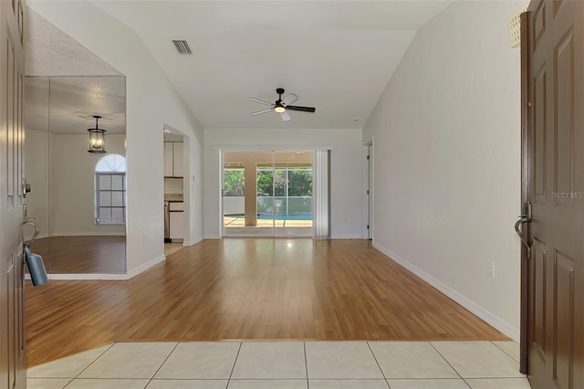 510 Border St, Port Charlotte, FL 33953 - unfurnished living room featuring a ceiling fan, light wood-style flooring, and vaulted ceiling