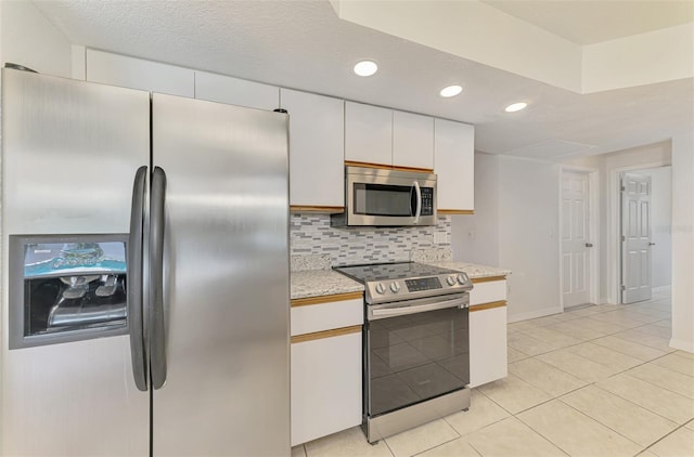 510 Border St, Port Charlotte, FL 33953 - kitchen with appliances with stainless steel finishes, decorative backsplash, white cabinets, recessed lighting, and light tile patterned floors