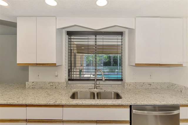 510 Border St, Port Charlotte, FL 33953 - kitchen featuring stainless steel dishwasher, white cabinets, light stone counters, a textured ceiling, and recessed lighting