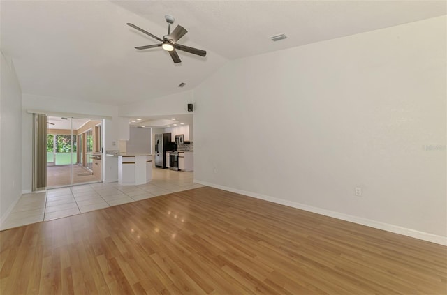 510 Border St, Port Charlotte, FL 33953 - unfurnished living room with vaulted ceiling, ceiling fan, and light wood-style floors