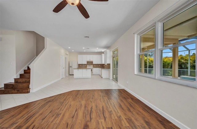 200 Valdiva St, Punta Gorda, FL 33983 - unfurnished living room featuring ceiling fan, light wood-type flooring, stairs, and recessed lighting