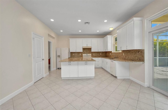 200 Valdiva St, Punta Gorda, FL 33983 - kitchen featuring white appliances, tasteful backsplash, under cabinet range hood, white cabinetry, and a kitchen island