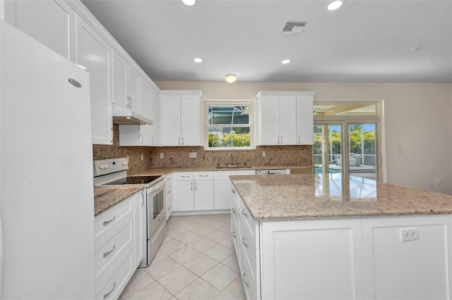 200 Valdiva St, Punta Gorda, FL 33983 - kitchen with white appliances, under cabinet range hood, a kitchen island, decorative backsplash, and recessed lighting