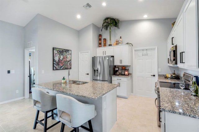 4321 NW 34th Ln, Cape Coral, FL 33993 - kitchen featuring stainless steel appliances, high vaulted ceiling, white cabinets, light stone counters, and a center island with sink