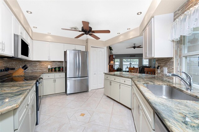 4142 Reif Ct, Port Charlotte, FL 33981 - kitchen featuring freestanding refrigerator, white microwave, electric range, a ceiling fan, and backsplash