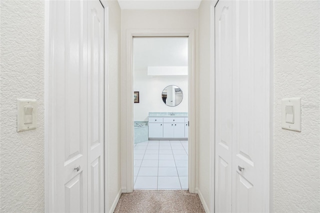 4142 Reif Ct, Port Charlotte, FL 33981 - hall featuring light colored carpet, a textured wall, and light tile patterned flooring