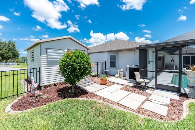 4142 Reif Ct, Port Charlotte, FL 33981 - rear view of house featuring glass enclosure, a patio area, roof with shingles, stucco siding, and an outdoor structure