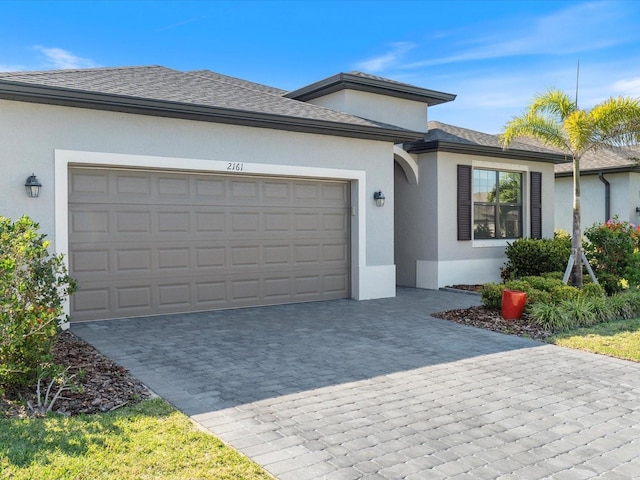 2161 Gardenia Ave, Port Charlotte, FL 33953 - ranch-style home with stucco siding, decorative driveway, a garage, and roof with shingles