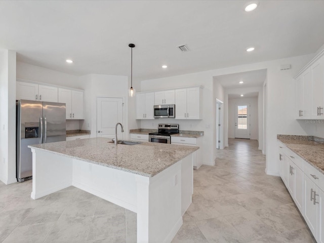 2161 Gardenia Ave, Port Charlotte, FL 33953 - kitchen with stainless steel appliances, recessed lighting, white cabinets, an island with sink, and light stone counters