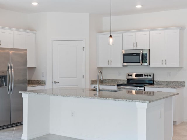2161 Gardenia Ave, Port Charlotte, FL 33953 - kitchen featuring stainless steel appliances, an island with sink, white cabinets, recessed lighting, and light stone countertops