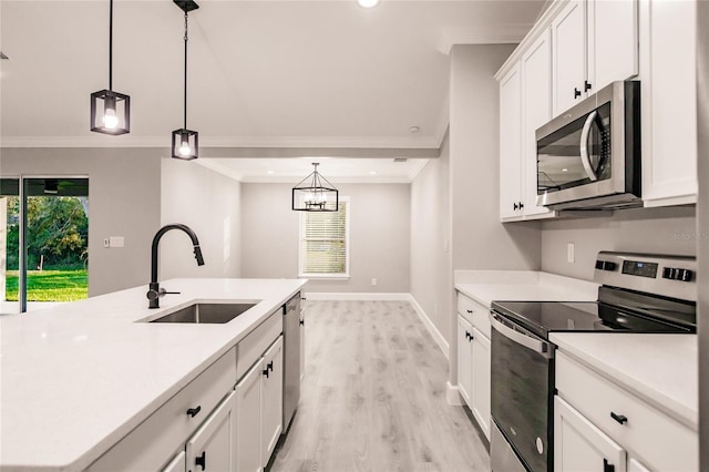 627 SE 22nd Ter, Cape Coral, FL 33990 - kitchen featuring appliances with stainless steel finishes, ornamental molding, light countertops, light wood-style flooring, and white cabinetry