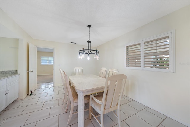 1915 Pebble Beach Ct, Venice, FL 34293 - dining area featuring a chandelier and light tile patterned floors