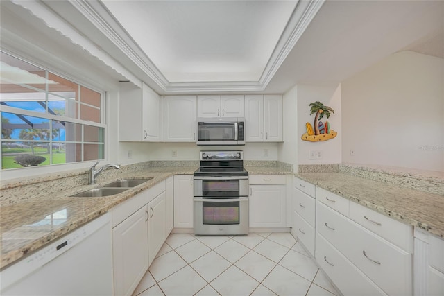 1915 Pebble Beach Ct, Venice, FL 34293 - kitchen with stainless steel appliances, white cabinetry, light stone countertops, and a raised ceiling