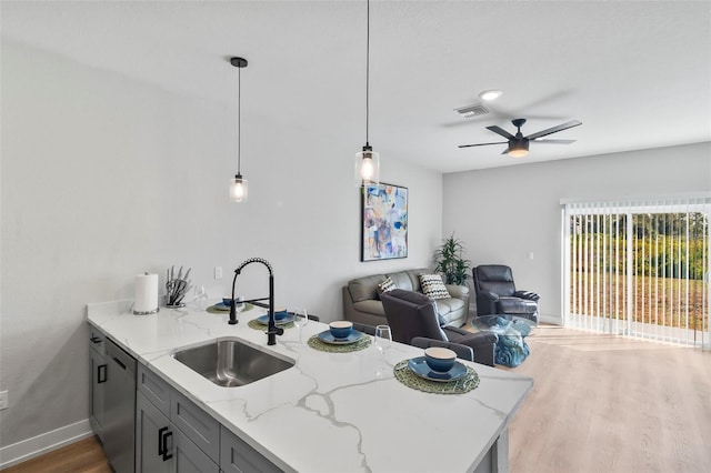 9155 Agate St, Port Charlotte, FL 33981 - kitchen with dishwasher, a ceiling fan, open floor plan, wood finished floors, and light stone counters