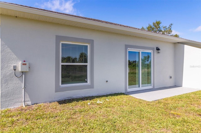 9155 Agate St, Port Charlotte, FL 33981 - rear view of house featuring stucco siding, a yard, and a patio