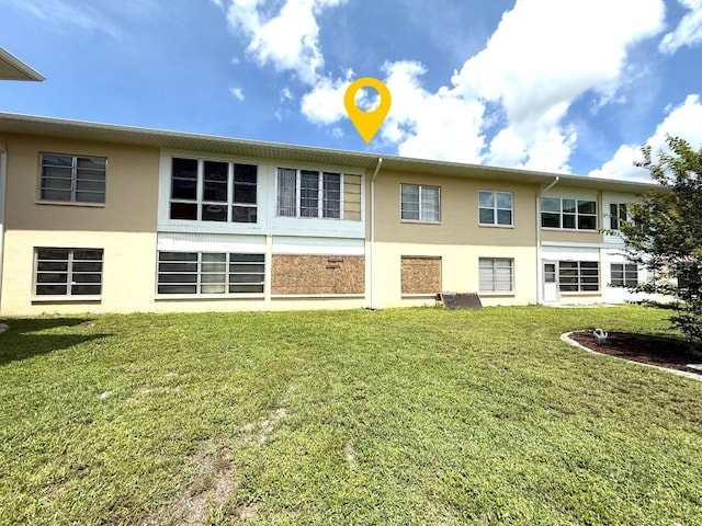 3116 Harbor Blvd Unit 3B, Port Charlotte, FL 33952 - back of house with stucco siding and a lawn