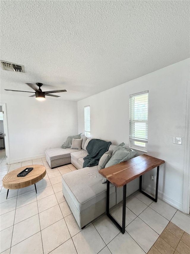 24 Charwood Cir, Lehigh Acres, FL 33936 - living room with healthy amount of natural light, light tile patterned flooring, a textured ceiling, and a ceiling fan