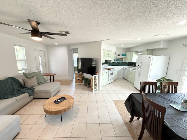 24 Charwood Cir, Lehigh Acres, FL 33936 - living area featuring a ceiling fan, healthy amount of natural light, light tile patterned flooring, and a textured ceiling