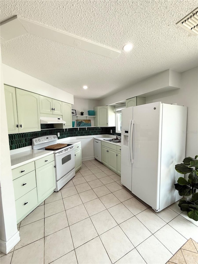 24 Charwood Cir, Lehigh Acres, FL 33936 - kitchen featuring white appliances, a textured ceiling, green cabinets, under cabinet range hood, and tasteful backsplash