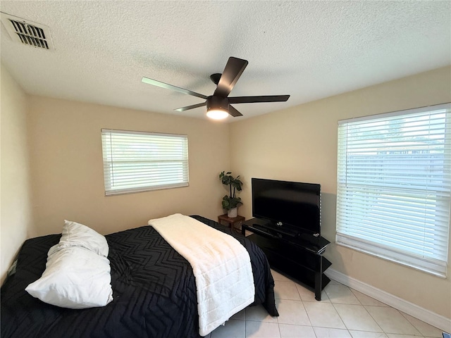 24 Charwood Cir, Lehigh Acres, FL 33936 - bedroom with light tile patterned flooring, a ceiling fan, and a textured ceiling