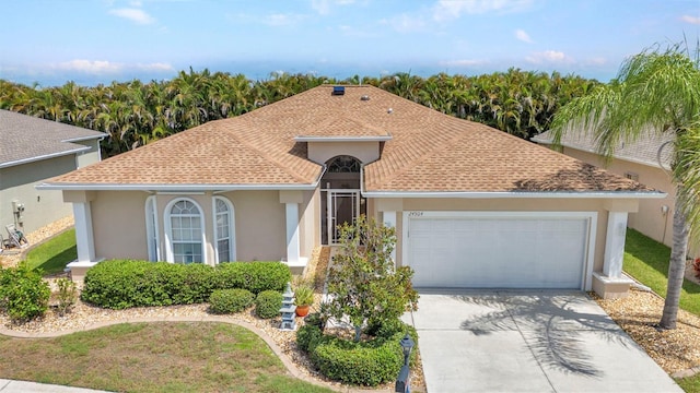 24504 Buckingham Way, Punta Gorda, FL 33980 - mediterranean / spanish house with stucco siding, a garage, a shingled roof, driveway, and a front lawn