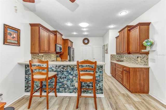 24504 Buckingham Way, Punta Gorda, FL 33980 - kitchen featuring stainless steel appliances, a ceiling fan, light countertops, and light wood-style flooring