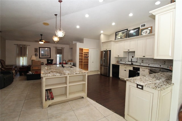 39 Norman St, Port Charlotte, FL 33954 - kitchen with stainless steel fridge with ice dispenser, open floor plan, cream cabinets, open shelves, and lofted ceiling