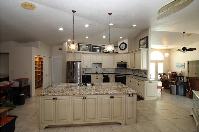 39 Norman St, Port Charlotte, FL 33954 - kitchen featuring cream cabinetry, appliances with stainless steel finishes, lofted ceiling, open floor plan, and a spacious island