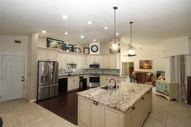 39 Norman St, Port Charlotte, FL 33954 - kitchen featuring stainless steel appliances, cream cabinetry, vaulted ceiling, light tile patterned floors, and a spacious island