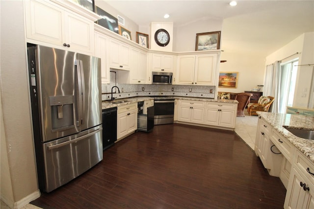 39 Norman St, Port Charlotte, FL 33954 - kitchen with appliances with stainless steel finishes, decorative backsplash, light stone counters, dark wood finished floors, and lofted ceiling