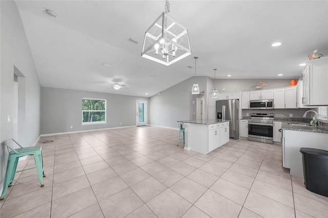 12112 Helios Ave, Port Charlotte, FL 33981 - kitchen with appliances with stainless steel finishes, lofted ceiling, open floor plan, white cabinets, and dark stone countertops