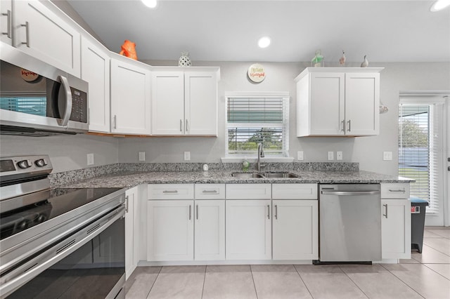12112 Helios Ave, Port Charlotte, FL 33981 - kitchen featuring appliances with stainless steel finishes, white cabinets, recessed lighting, light tile patterned floors, and light stone counters