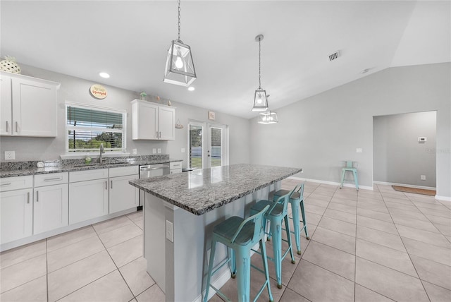 12112 Helios Ave, Port Charlotte, FL 33981 - kitchen with light tile patterned floors, lofted ceiling, dark stone counters, white cabinets, and healthy amount of natural light
