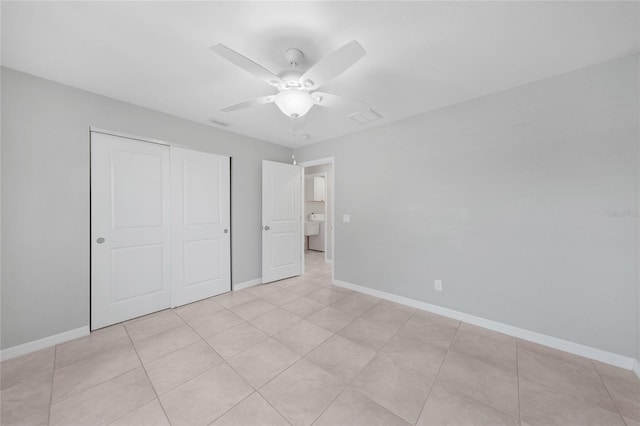 12112 Helios Ave, Port Charlotte, FL 33981 - unfurnished bedroom with a closet, ceiling fan, light tile patterned flooring, and washer / dryer