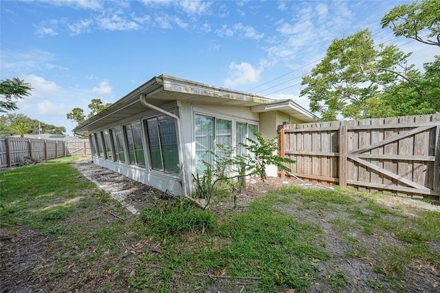 475 Whippoorwill Dr, Venice, FL 34293 - view of property exterior with a fenced backyard, a sunroom, and stucco siding