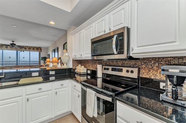 900 E Marion Ave Unit 1403, Punta Gorda, FL 33950 - kitchen featuring stainless steel appliances, backsplash, white cabinets, open floor plan, and dark stone counters