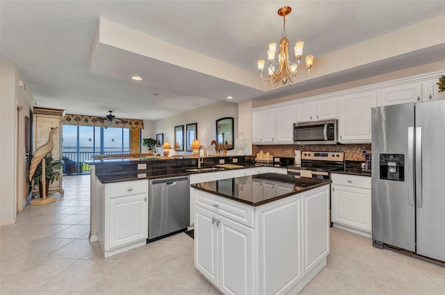 900 E Marion Ave Unit 1403, Punta Gorda, FL 33950 - kitchen featuring stainless steel appliances, a peninsula, a chandelier, backsplash, and white cabinetry