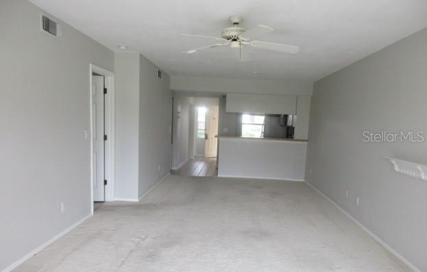 429 Cerromar Ln Unit 353, Venice, FL 34293 - unfurnished living room with light carpet and a ceiling fan