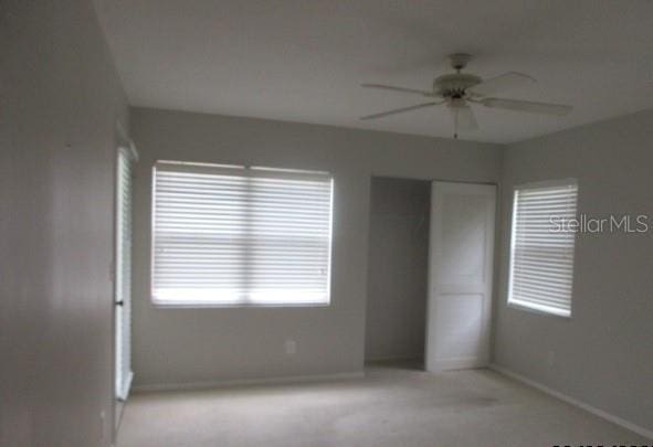 429 Cerromar Ln Unit 353, Venice, FL 34293 - unfurnished bedroom featuring light colored carpet, a closet, and a ceiling fan
