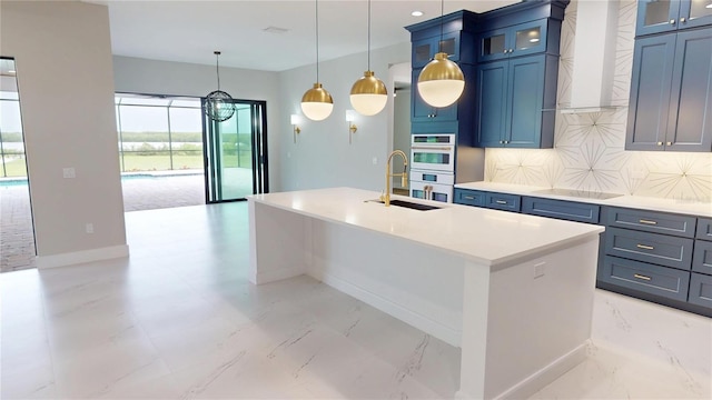 2073 Treasure Ln, Punta Gorda, FL 33982 - kitchen featuring double oven, an island with sink, tasteful backsplash, light countertops, and hanging light fixtures