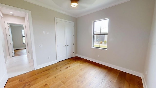 2073 Treasure Ln, Punta Gorda, FL 33982 - unfurnished bedroom featuring ornamental molding, light wood-style flooring, a closet, and a ceiling fan