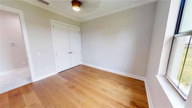 2073 Treasure Ln, Punta Gorda, FL 33982 - unfurnished bedroom featuring wood finished floors, ornamental molding, a closet, and a ceiling fan