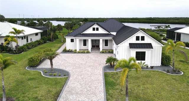2073 Treasure Ln, Punta Gorda, FL 33982 - modern farmhouse style home with board and batten siding, a standing seam roof, decorative driveway, and a front lawn