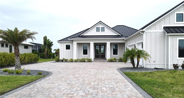 2073 Treasure Ln, Punta Gorda, FL 33982 - modern inspired farmhouse with board and batten siding, a standing seam roof, driveway, covered porch, and a front lawn