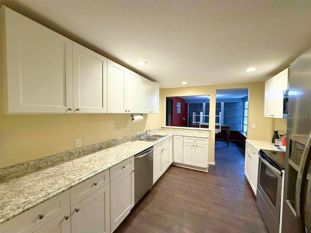 1426 Gary St, Punta Gorda, FL 33982 - kitchen featuring appliances with stainless steel finishes, dark wood-style floors, white cabinets, a peninsula, and a textured ceiling